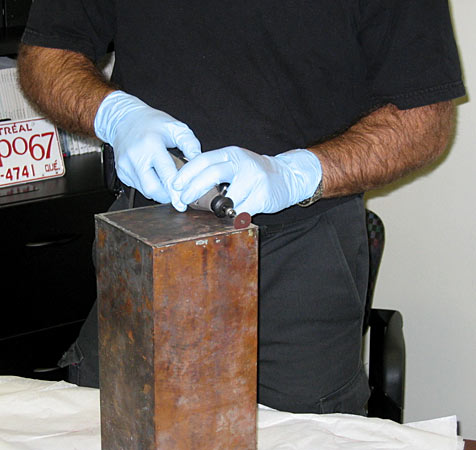 McGill's Waste Management Program manager Claude Lahaie begins cutting open the time capsule. Photo by David Kemper/McGill University Archives.